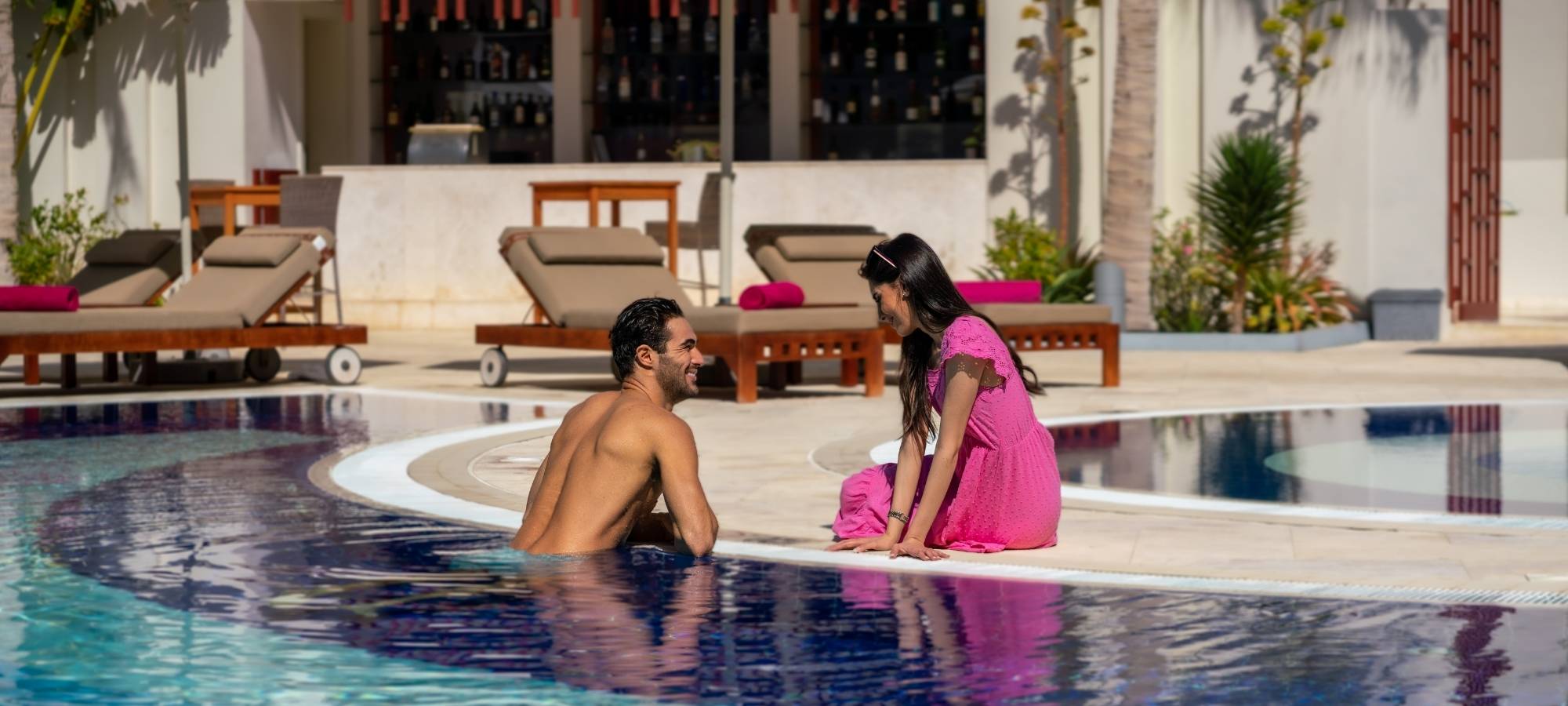 A man standing in the pool while looking for his partner at Sifawy Boutique hotel